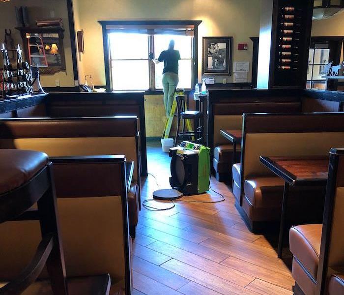 Restaurant booths with SERVPRO employee and equipment