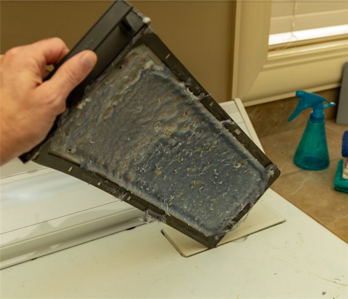 a lint tray from a drying machine that is full of lint