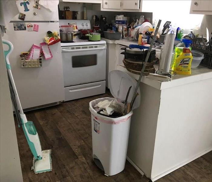 Stacked items on countertop in kitchen, wet floor
